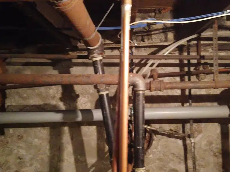 Open basement plumbing rough-in with exposed pipes for santa ana in Santa Ana