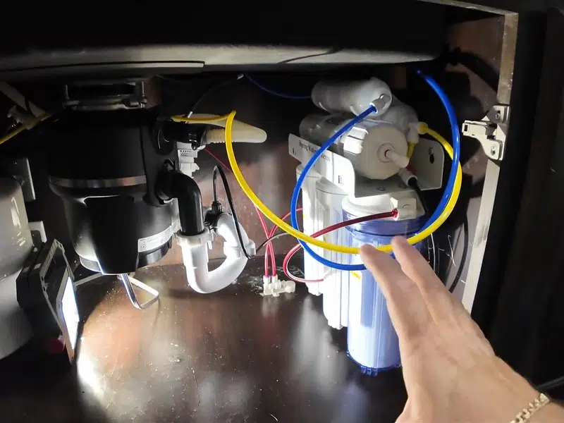 Under-sink view of disposal and dishwasher hose connection for garbage disposal in Stanton