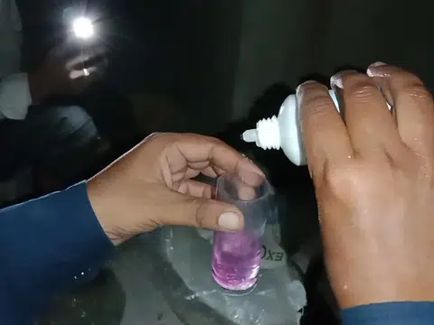 Purple water hardness test sample in small cup for plumbing blog index in Stanton