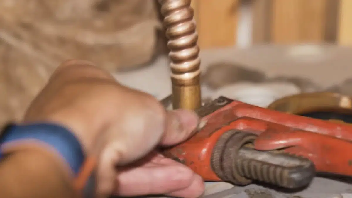 Plumber using wrench on metal drain cleanout fitting for stanton central park area in Stanton Central Park Area