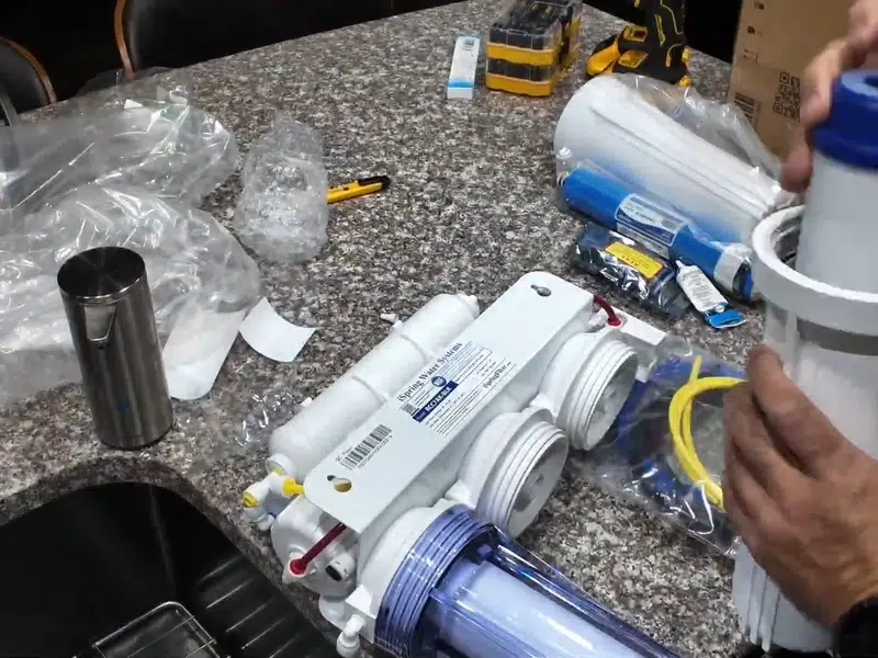 Reverse osmosis filter parts and tubing spread under sink for water filtration in Stanton