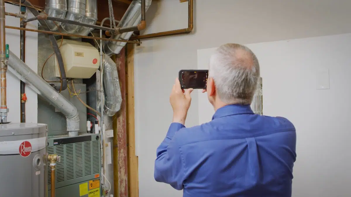 Technician photographing water heater and softener equipment for water softener in Stanton
