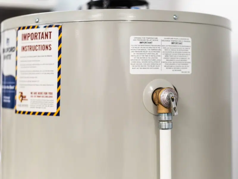 Standard tank water heater with visible warning label for rental property water heater requirementslifornia in Stanton