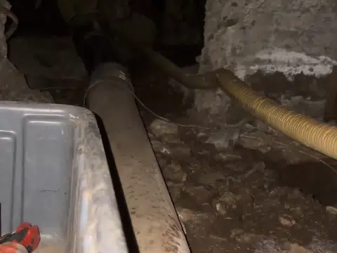 Tight crawlspace with exposed plumbing and insulation for index in Stanton
